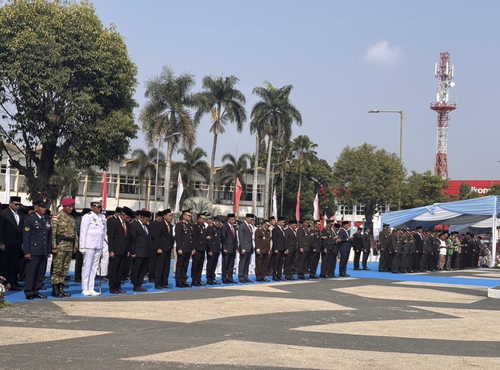 Bupati Jember beserta jajaran pejabat Forkopimda berdiri bersama peserta upacara di lapangan terbuka tanpa tenda saat peringatan HUT RI 81 tanpa tenda.